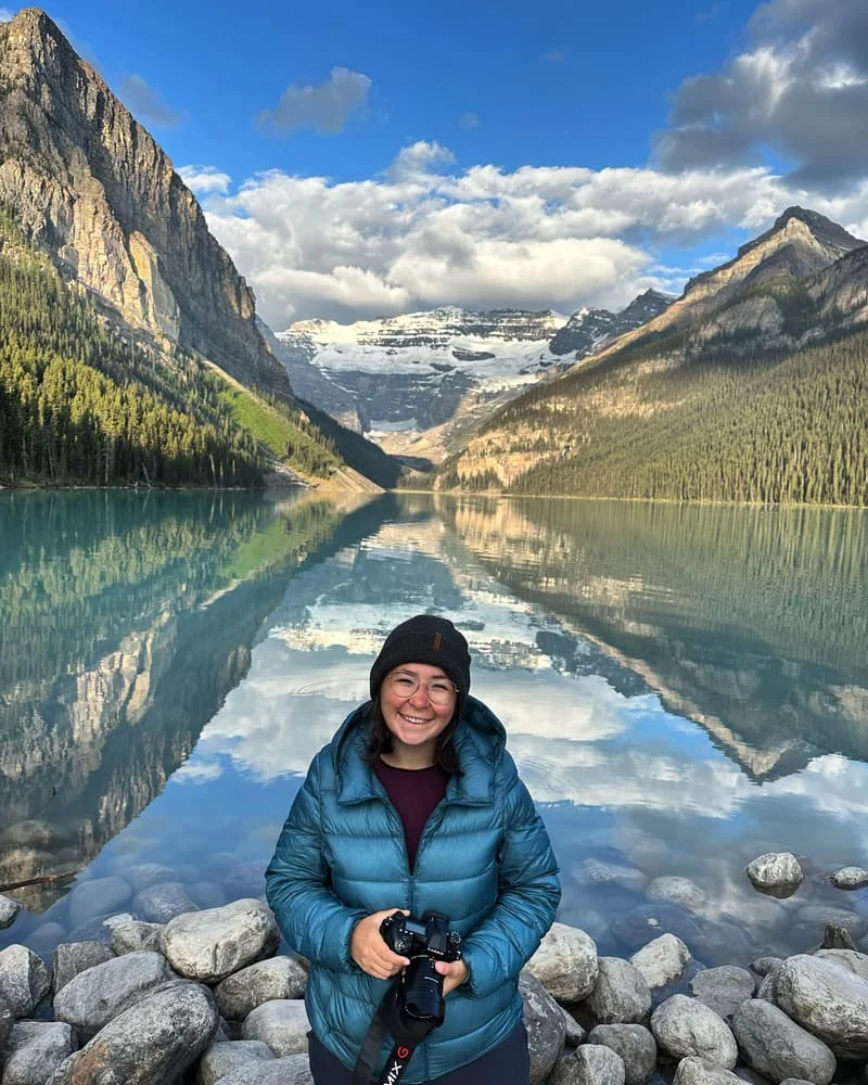 Audrey au lac Louise au Canada, entourée de montagnes et d'un reflet parfait dans l'eau